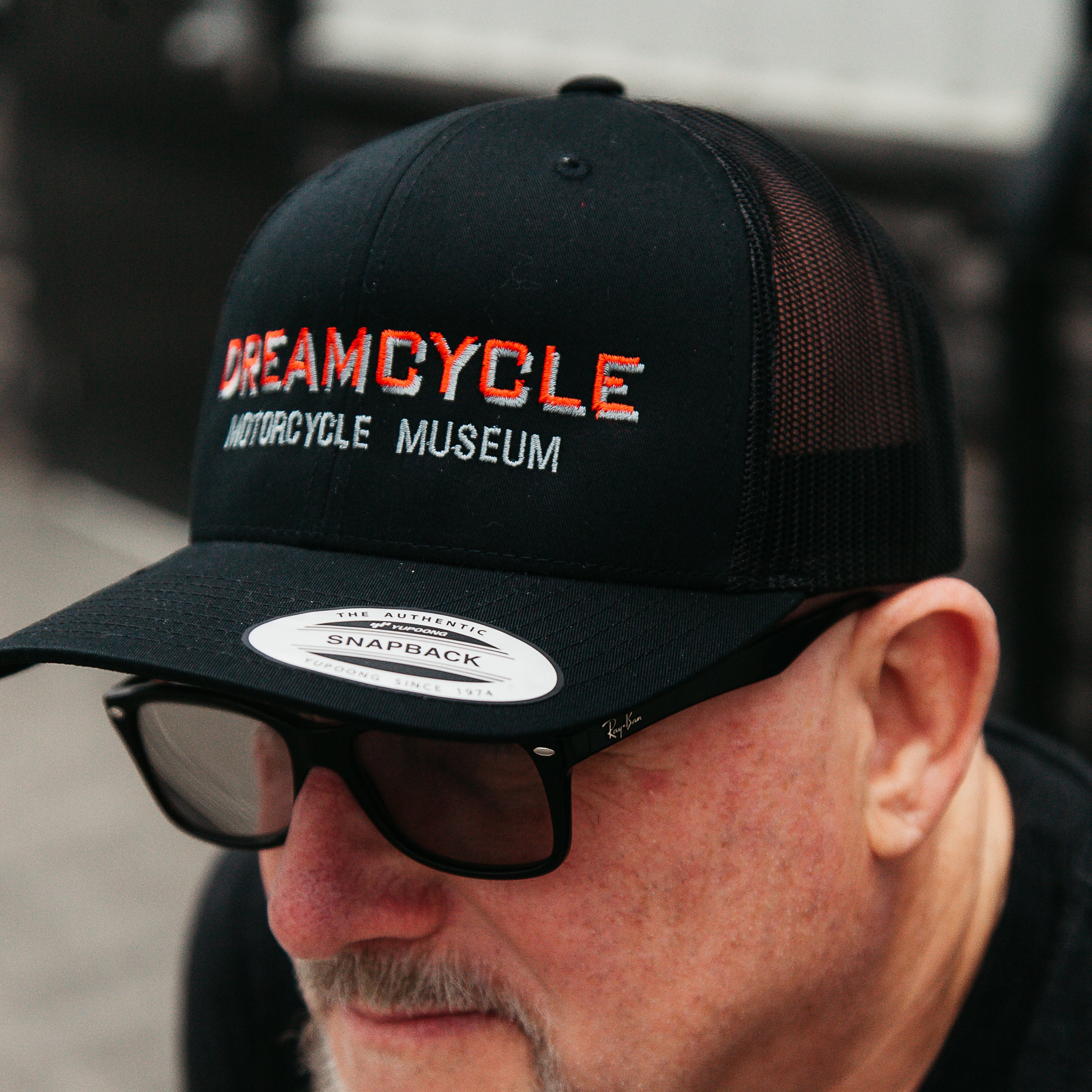 Dreamcycle Motorcycle Museum | Man wearing dreamcycle trucker hat in lifestyle setting.