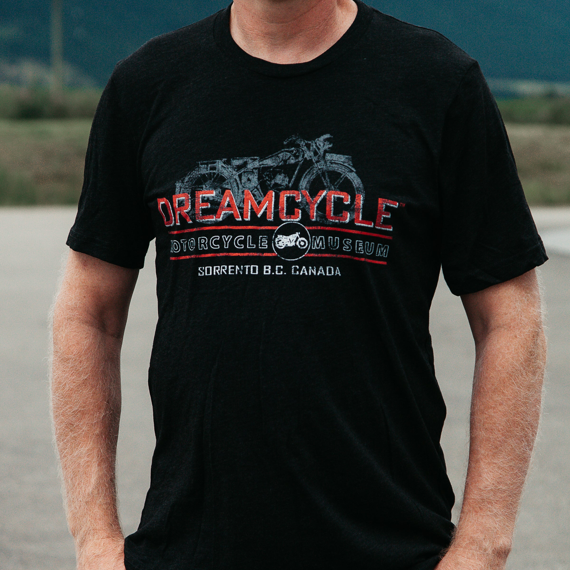Dreamcycle Motorcycle Museum | Closeup man modeling dreamcycle tshirt with motorcycle.